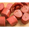 Close-up of sliced smoked and pickled bologna pieces with visible mustard seeds and a smoked chili, showcasing a handcrafted meat product from USA made collections including Kitchen & Food, Food, Meats, and Best Sellers.