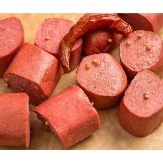 Close-up of sliced smoked and pickled bologna pieces with visible mustard seeds and a smoked chili, showcasing a handcrafted meat product from USA made collections including Kitchen & Food, Food, Meats, and Best Sellers.