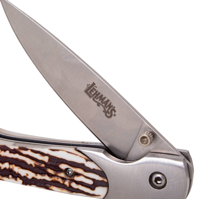 Close-up of a folding knife with a stainless steel blade engraved with Lehman's logo, featuring a textured antler handle, part of Farm, Garden & Tool and Pocket Knives collections.