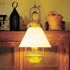 Warm glowing hanging lamp with a clear glass oil reservoir and brass tilt-frame hanger, illuminating rustic wooden furniture, featured in Farm, Garden & Tool and Lamps & Lighting collections.