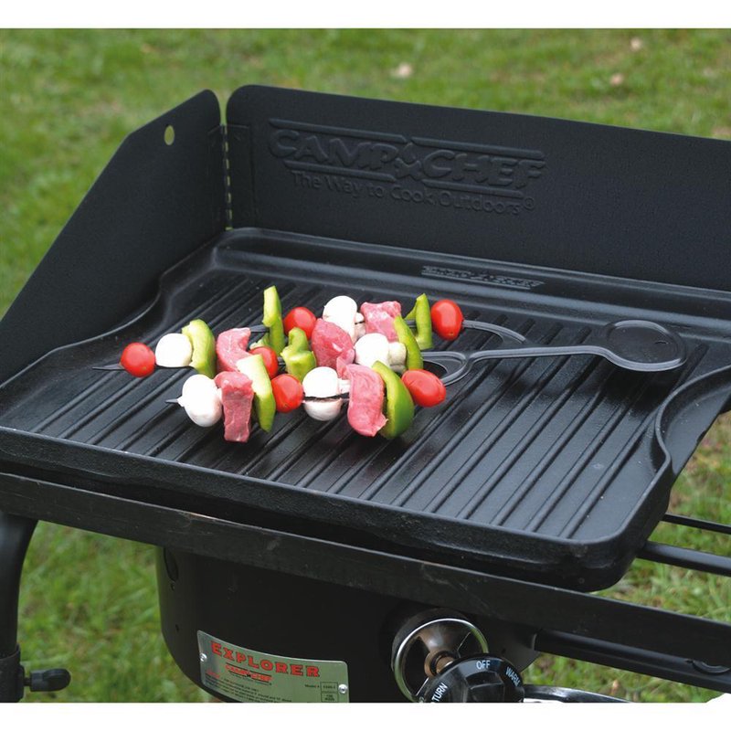 Large pre-seasoned cast iron grill surface shown grilling colorful vegetable and meat skewers outdoors, ideal for camping, farm, garden, and kitchen use within cookware and cast iron collections.