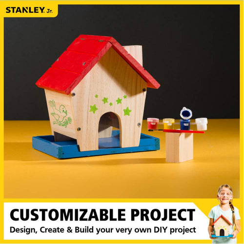 Unfinished wooden bird feeder with red roof and blue base, decorated with green stars and a bird illustration, accompanied by paint pots and brush, ideal for children's arts and crafts and animal care collections.