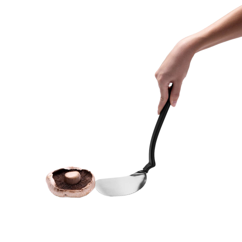 Flexible stainless steel grill spatula with black ergonomic handle held above a portobello mushroom, designed for flipping, cutting, and scraping in Kitchen & Food and Grilling collections.