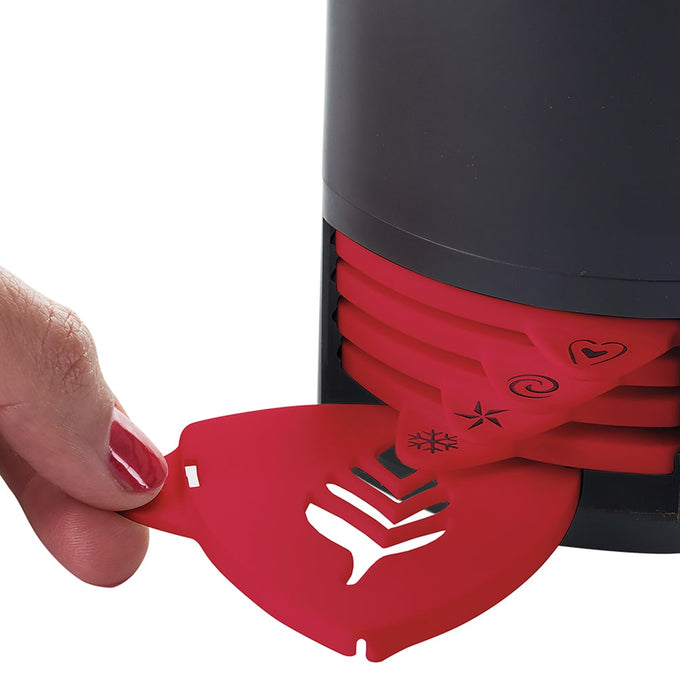 Hand holding a red stencil with a leaf pattern being removed from a black holder containing six interchangeable coffee stencils, part of Kitchen & Food and Brewing Coffee and Tea collections.