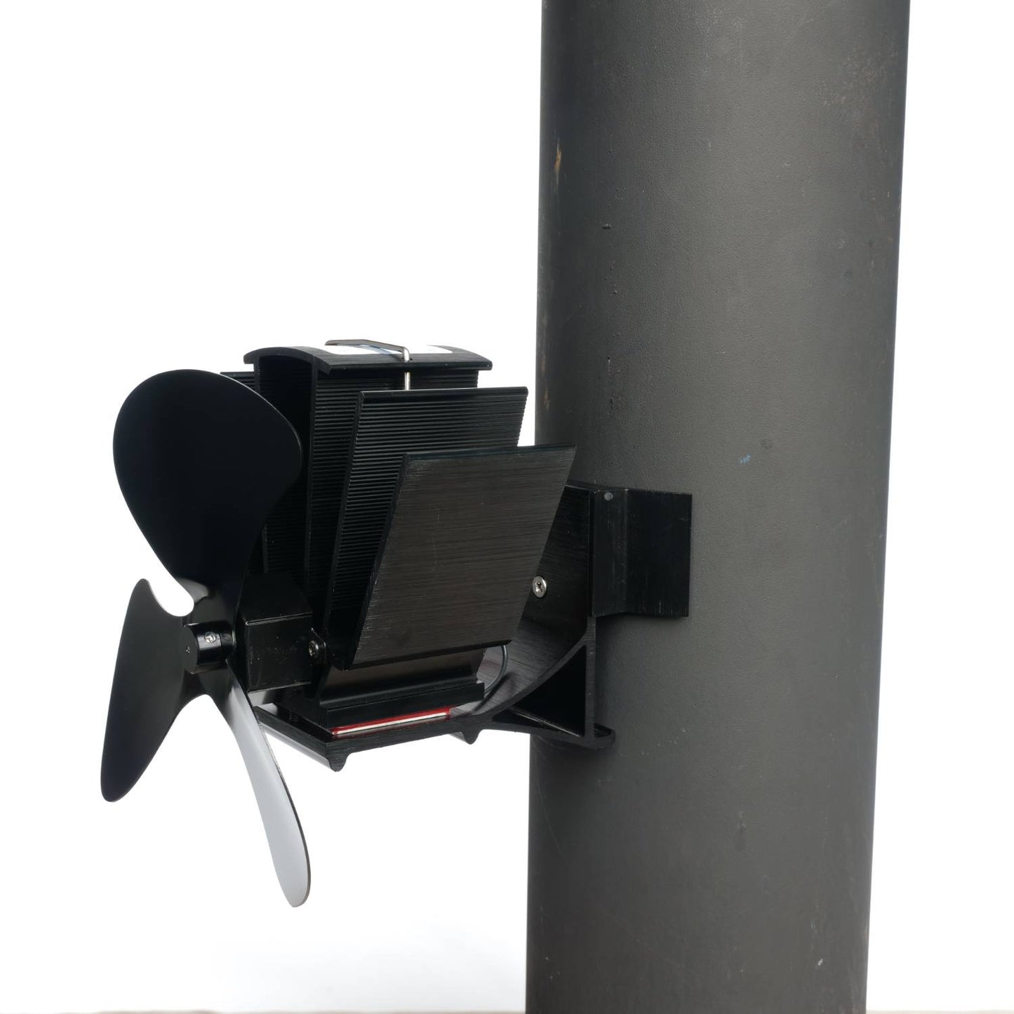 Black heat-powered magnetic stove fan with three blades, mounted on a flue pipe, designed for efficient warm air circulation; featured in Hearth Accessories and Best Sellers collections.