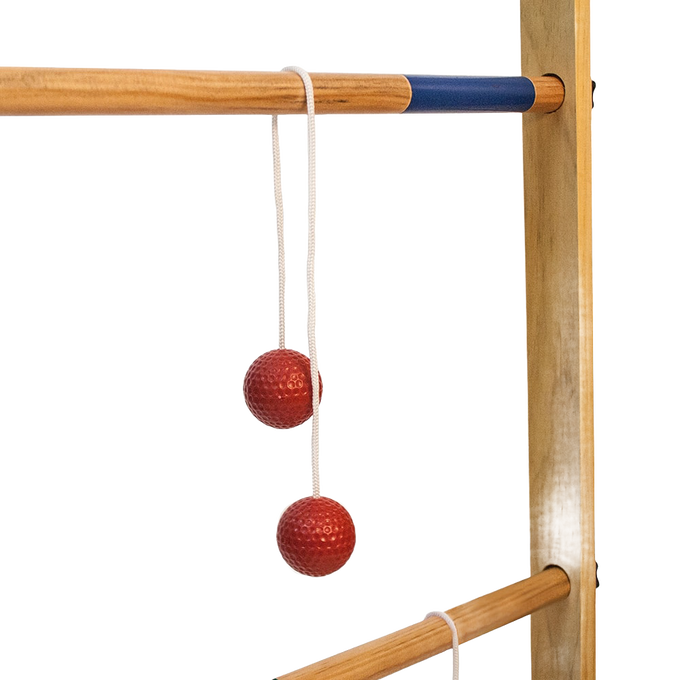 Close-up of a handcrafted wooden ladder frame with natural finish and blue accent rung, featuring red golf ball bolas hanging by white cords, ideal for lawn games collections.
