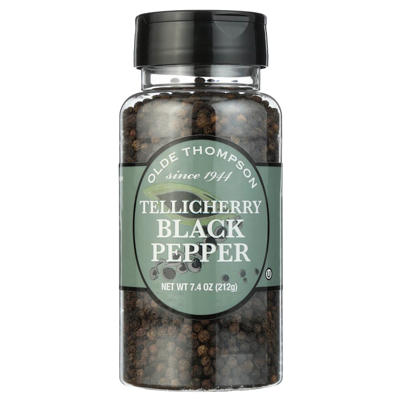 Clear plastic bottle filled with whole Tellicherry black peppercorns, featuring a black screw cap and green label, ideal for kitchen, pantry, and grilling collections.