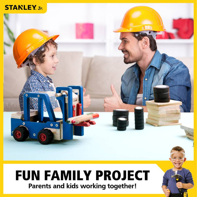 Young child and adult wearing yellow safety helmets giving thumbs up next to a handcrafted wooden forklift toy with blue and natural wood tones, black and red wheels, surrounded by wooden blocks and tires, promoting indoor play, arts and crafts, and children’s toys collections.