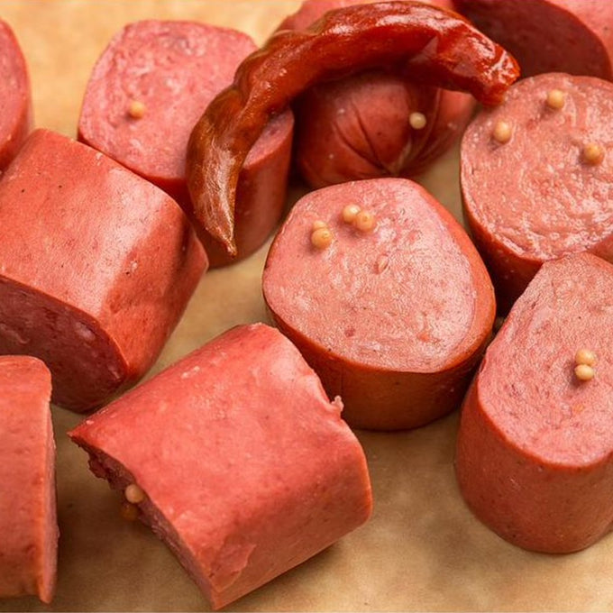 Slices of smoked pickled bologna with mustard seeds and a dried chili pepper, showcasing handcrafted meat made in USA, featured in Kitchen & Food, Food, Meats, and Best Sellers collections.