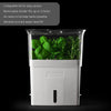 Clear herb keeper with white base featuring removable divider for up to three herbs, built-in air vents for breathability, and a refill window to monitor water level in kitchen collections.