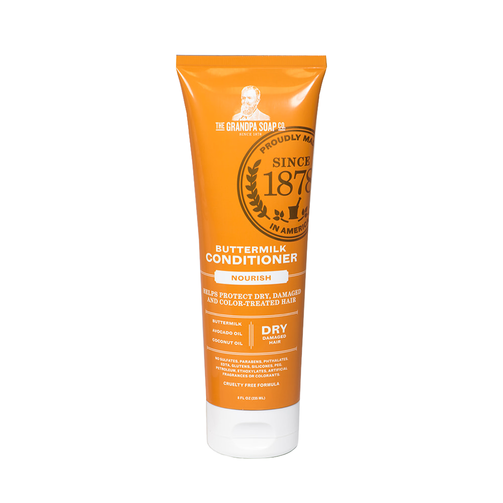 Bright orange tube of buttermilk conditioner labeled for nourishing dry, damaged, and color-treated hair, handcrafted and made in USA, featured in Health & Wellness and Grooming collections.