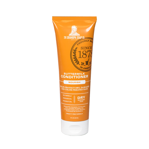 Bright orange tube of buttermilk conditioner labeled for nourishing dry, damaged, and color-treated hair, handcrafted and made in USA, featured in Health & Wellness and Grooming collections.
