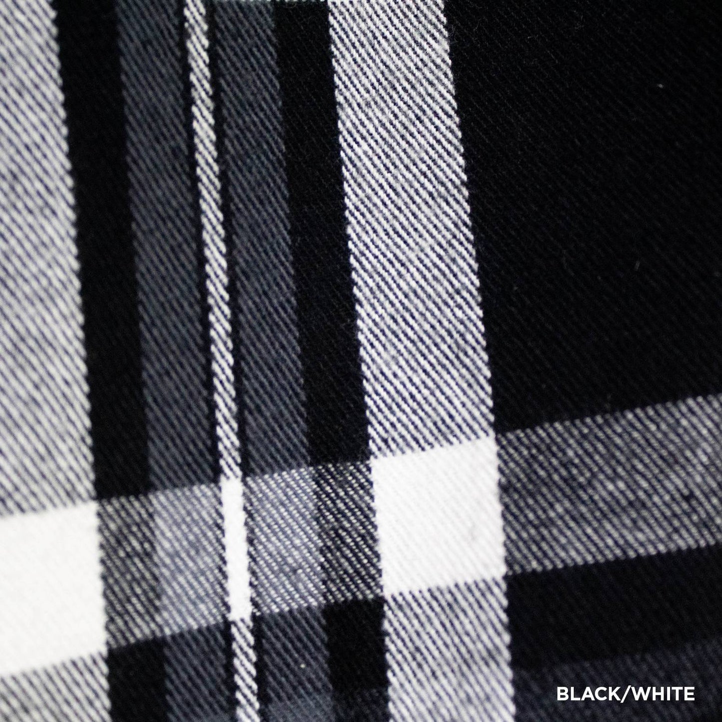 Close-up of handcrafted black and white flannel fabric with a classic plaid pattern, highlighting detailed woven texture, featured in clothing and accessories collections.
