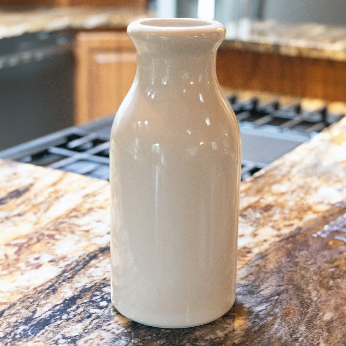 Cream-colored handcrafted stoneware bottle with smooth glazed finish, styled for farmhouse decor and kitchen use, featured in Home & Decor, Kitchen & Food, and USA Made collections.