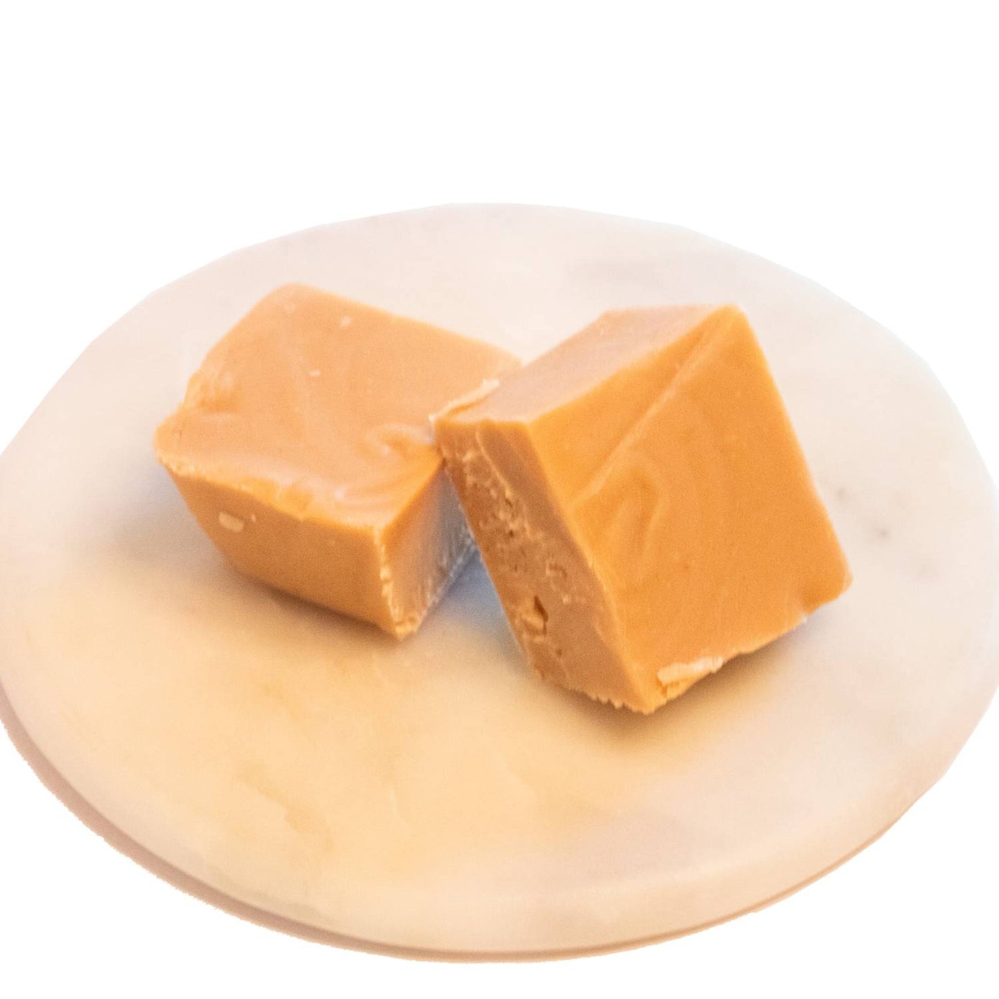 Two handcrafted creamy caramel-colored fudge pieces with a smooth, melt-in-your-mouth texture on a white marble plate, featured in Kitchen & Food, Snacks and Sweets, USA Made, Best Sellers, and Promo Eligible collections.