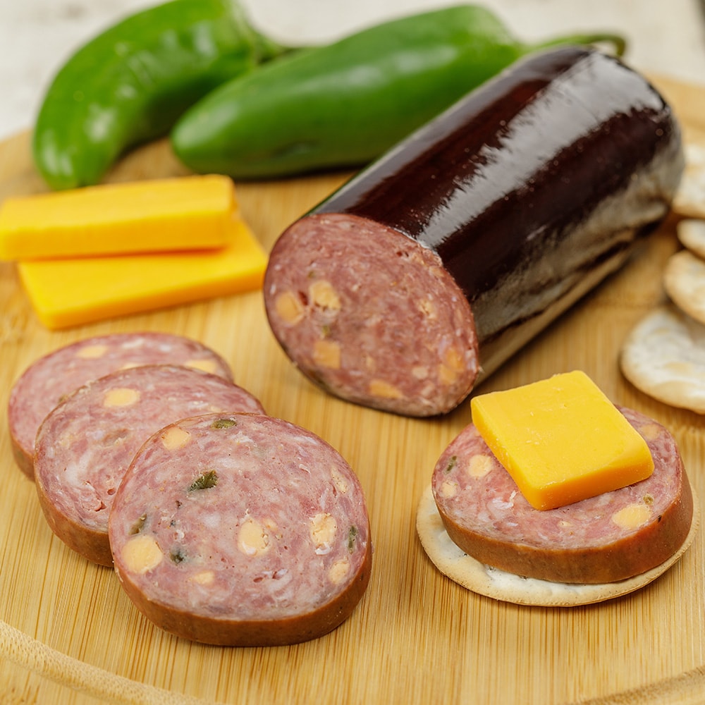 Handcrafted summer sausage from Amish Country with slices featuring embedded cheese, served on crackers alongside cheddar cheese slices, green peppers, and crackers in Kitchen & Food, Snacks and Sweets, Pantry, Meats, USA Made, and Best Sellers collections.