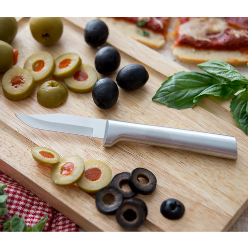 Sharp paring knife with a carbon stainless steel blade and satin-finished cast aluminum handle on a wooden cutting board with sliced green and black olives, fresh basil leaves, and pizza in a kitchen food prep setting, ideal for Farm, Garden & Tool and Kitchen & Food collections.