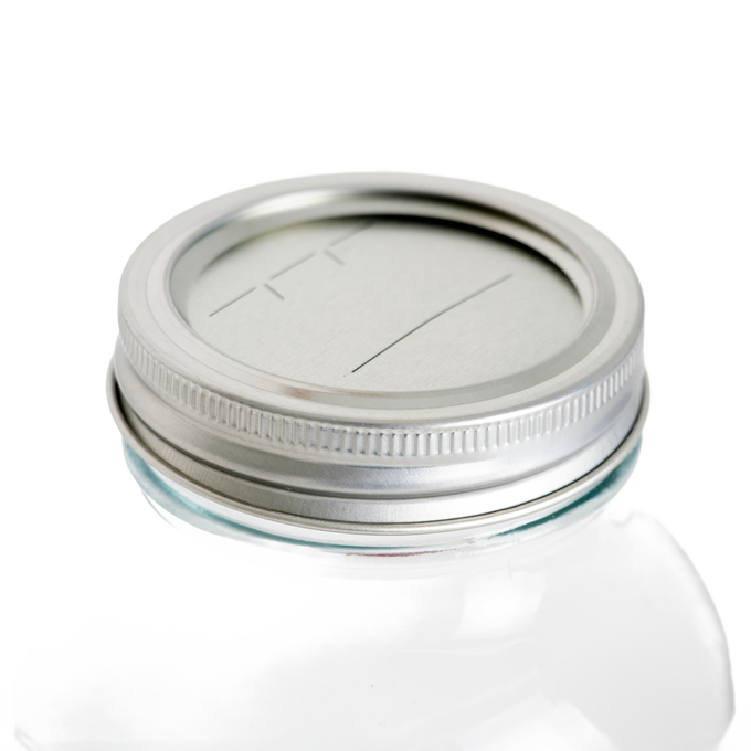 Silver metal regular-mouth canning lid and band set with BPA-free sealing compound on a clear glass jar, ideal for kitchen food preservation in Canning and Kitchen & Food collections.