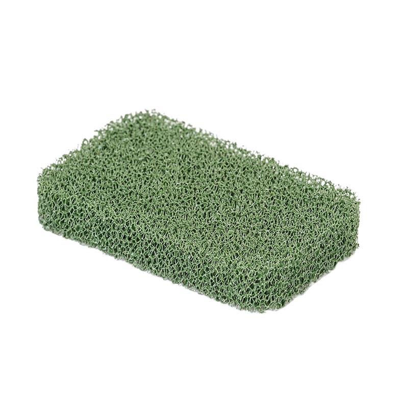 Green silicone cooktop scrubber with a porous texture, designed for durable, odor-resistant cleaning in household and kitchen settings, made in USA.