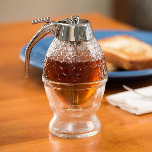 8 oz glass honey and syrup dispenser with textured honeycomb design and metal lever on a glass stand, displayed on a wooden table with toast and napkin, ideal for Kitchen & Food, Storage and Serving, Best Sellers, and Promo Eligible collections.