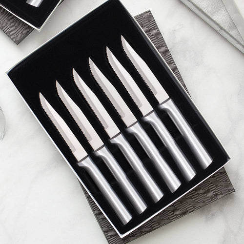 Set of six handcrafted steak knives with smooth stainless steel handles and single-sided serrated blades, made in the USA, ideal for kitchen, food prep, and knife collections.