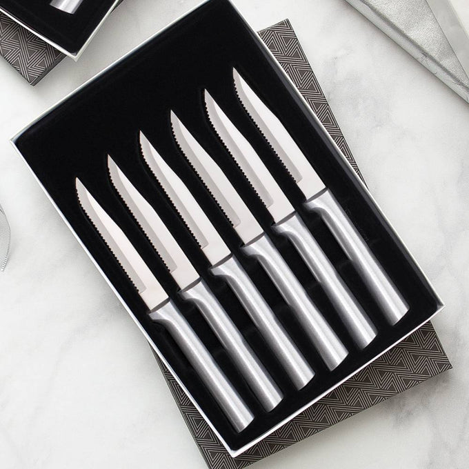 Set of six handcrafted steak knives with smooth stainless steel handles and single-sided serrated blades, made in the USA, ideal for kitchen, food prep, and knife collections.