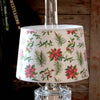 Festive parchment lamp shade with holly, poinsettias, and pine sprigs, designed to soften light for Aladdin lamps; included in Lamps & Lighting and Lamp Shades collections.