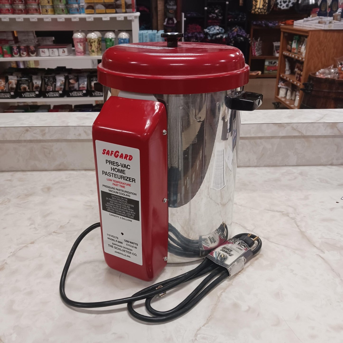 Compact home milk pasteurizer with polished metal body and red top, featuring an electric heating unit and cord, ideal for farm, garden & tool, and animal care collections.