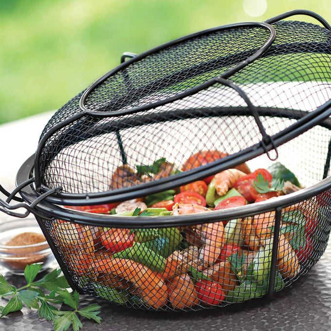 Black wire mesh grill basket with lid holding colorful grilled vegetables and shrimp, designed for smoky flavor infusion, ideal for outdoor cooking in kitchen and grilling collections.