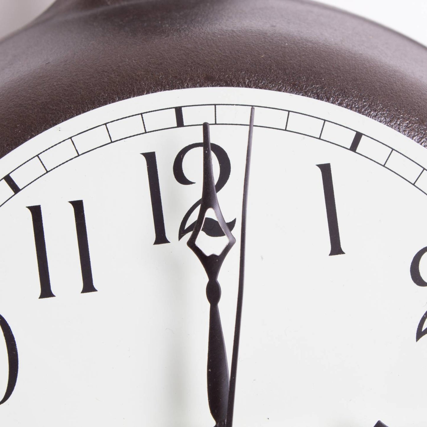 Close-up of a handcrafted clock face with black hour and minute hands pointing to twelve, featuring large black numerals on a white background, part of a heavy cast iron frame in a USA Made decor collection.