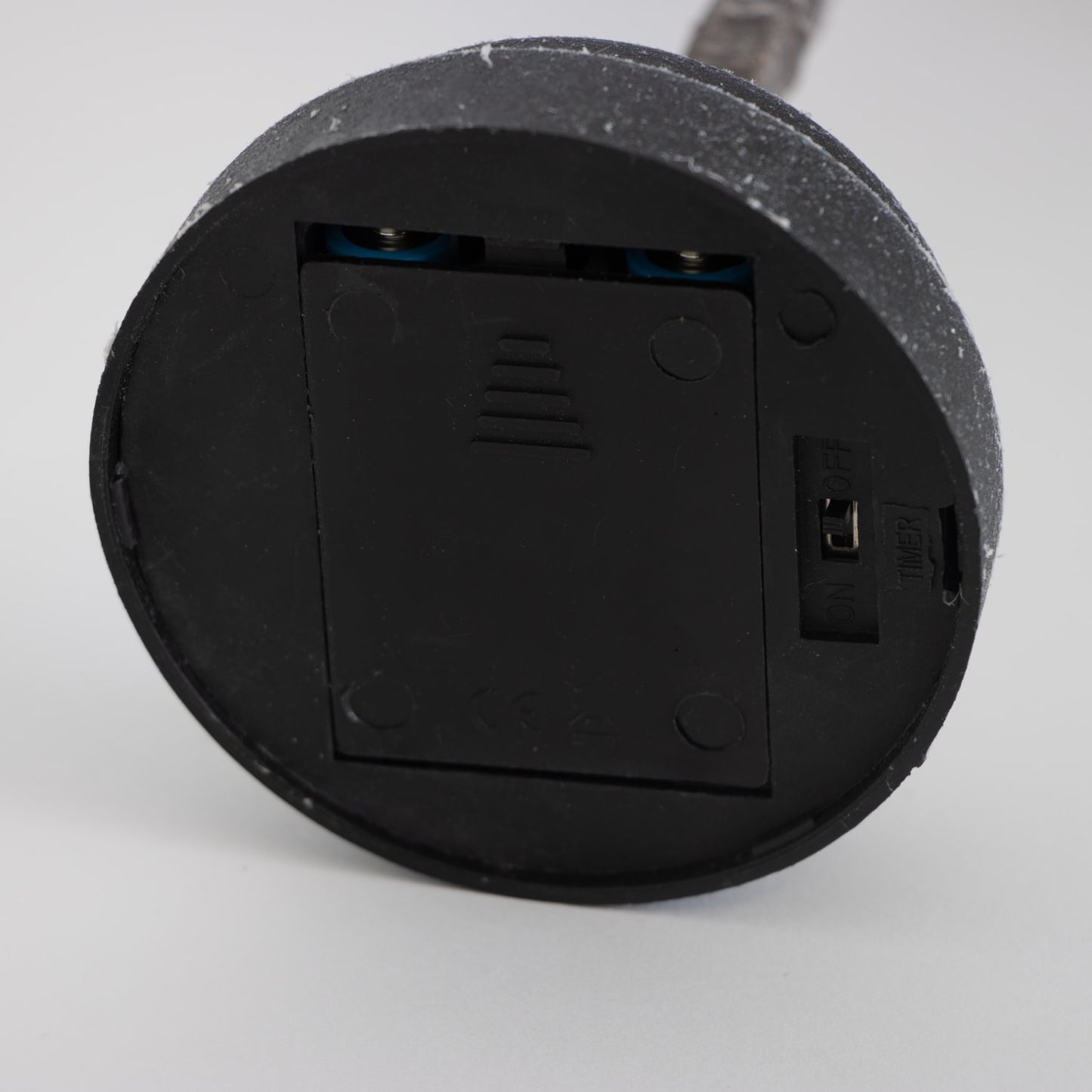 Close-up of the battery compartment and on/off switch on the base of a handcrafted lighted holiday tree, designed for easy portable use in Home & Decor and Holiday Decor collections.