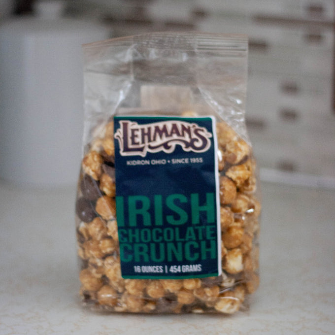 Clear bag of handcrafted caramel popcorn blended with Irish chocolate crunch pieces, a unique sweet and crunchy snack made in USA, perfect for Kitchen & Food, Snacks and Sweets, Popcorn, USA Made, Best Sellers, and Promo Eligible collections.