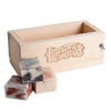 Handcrafted wooden soap loaf mold made from durable pine with engraved branding, accompanied by three artisan soap bars, featured in Health & Wellness and Soaps and Soapmaking collections.