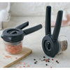 Two black-handled spice mills with clear containers filled with pink salt crystals and mixed peppercorns, designed for Kitchen & Food, Dinnerware, Kitchen Gadgets, Cooking and Baking Helpers, Storage and Serving, Best Sellers, and Promo Eligible collections.