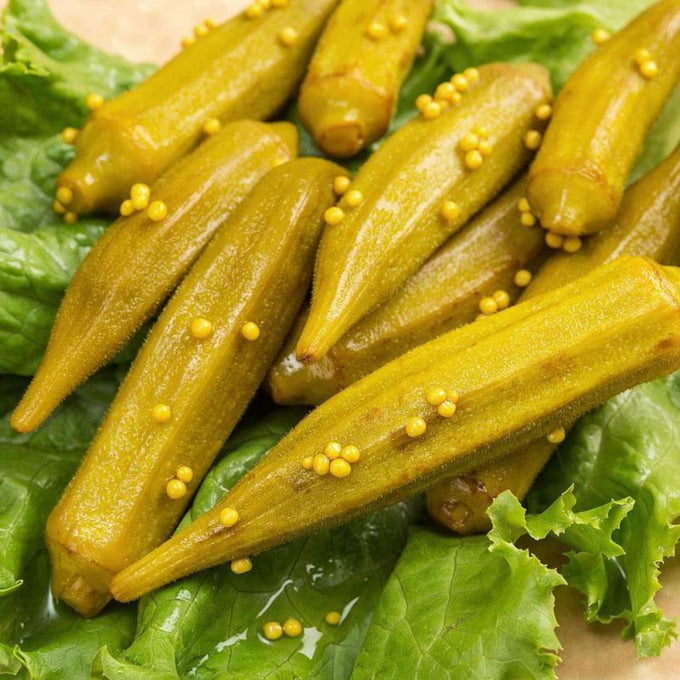 Close-up of handcrafted pickled okra with mustard seeds resting on fresh green lettuce, highlighting wholesome Amish-made quality for Kitchen & Food, Pantry, USA Made, and Best Sellers collections.