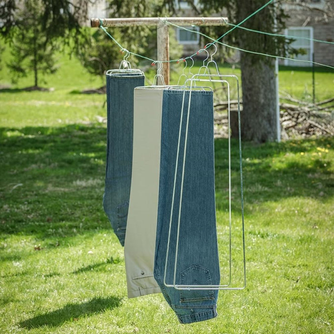 Two pairs of rust-resistant steel pant stretchers hanging on a clothesline outdoors to maintain creases and improve fit, featured in Home & Decor and Laundry Supplies collections.