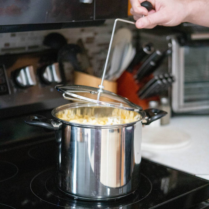 Shiny stainless steel stovetop popcorn popper with black handles and glass lid featuring a hand crank, handcrafted for Kitchen & Food, Cookware, Pots and Pans, and Best Sellers collections.