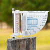 White multi-function weather meter with rain gauge, thermometer, wind chill chart, and wind speed indicator mounted on weathered wood post, ideal for Farm, Garden & Tool and Garden Accessories collections.