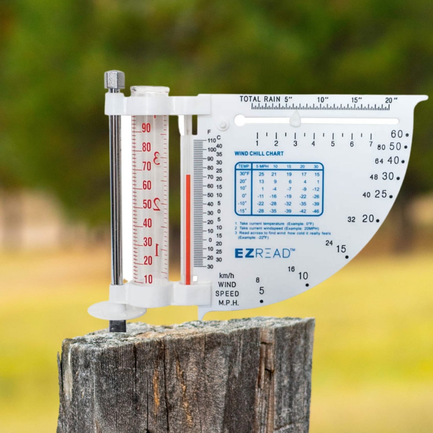 White multi-function weather meter with rain gauge, thermometer, wind chill chart, and wind speed indicator mounted on weathered wood post, ideal for Farm, Garden & Tool and Garden Accessories collections.