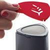 Hand holding a red stencil featuring a leaf pattern above a black powder shaker with a mesh top, designed for creating decorative cappuccino art, featured in Kitchen & Food and Brewing Coffee and Tea collections.