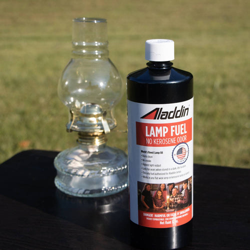 Black 32 oz bottle of lamp fuel labeled no kerosene odor next to a clear glass oil lamp, suitable for Lamps & Lighting, Lamp and Lantern Fuel, Parts and Accessories, Best Sellers, and Promo Eligible collections.