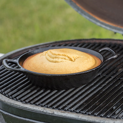 Handcrafted cast iron round pan with short side handles baking golden cornbread on an outdoor grill, part of Kitchen & Food, Cookware, Cast Iron, Best Sellers, Promo Eligible collections.
