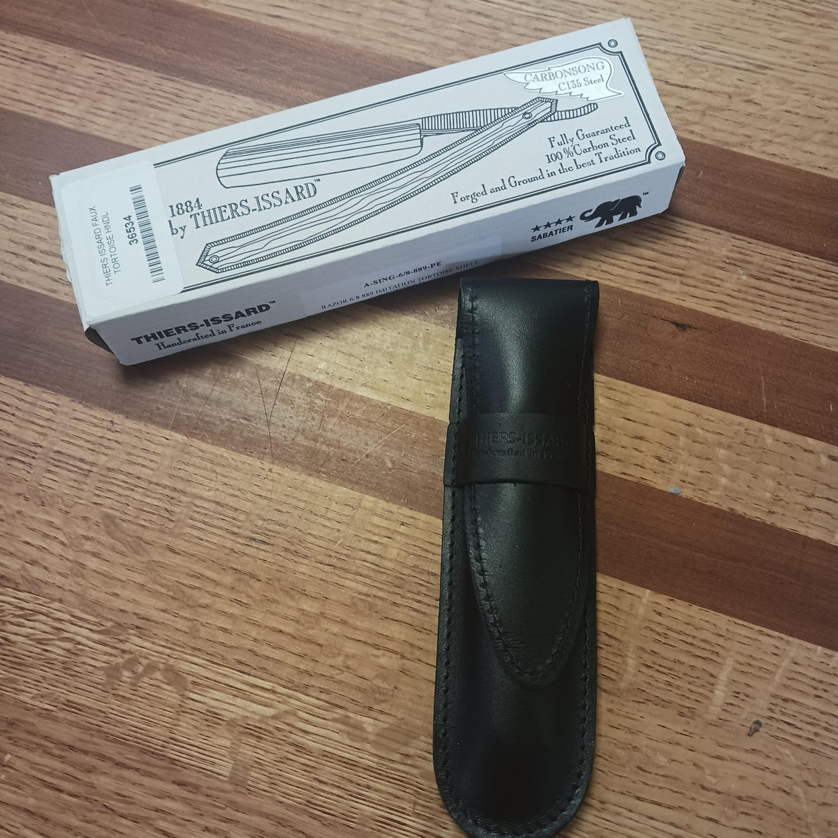 Leather razor case beside a white rectangular box with black line art of a straight razor, featured in Health & Wellness, Grooming and Personal Hygiene, Best Sellers, and Promo Eligible collections.
