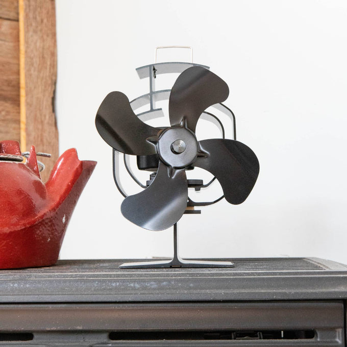 Handcrafted black heat-powered oscillating stove fan with four wide blades and protective guard, designed to circulate warm air efficiently in stoves and hearth accessories collections.
