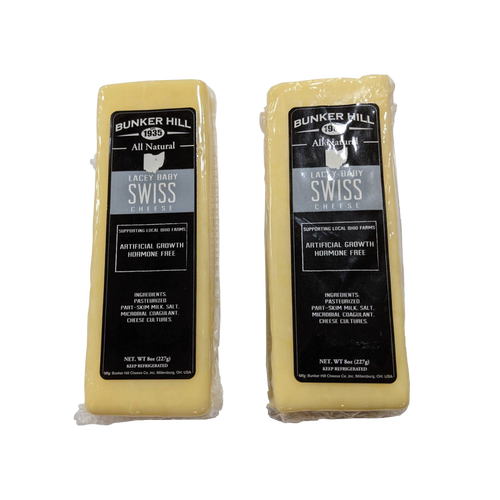Two blocks of handcrafted all-natural Lacey Baby Swiss cheese with black and silver labels, made in the USA, perfect for Kitchen & Food, Food, Meats, and Best Sellers collections.