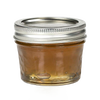 Small clear glass jar with quilted texture and silver metal lid, filled with golden jam, ideal for kitchen, food preservation, and canning uses, handcrafted in USA.
