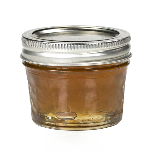 Small clear glass jar with quilted texture and silver metal lid, filled with golden jam, ideal for kitchen, food preservation, and canning uses, handcrafted in USA.