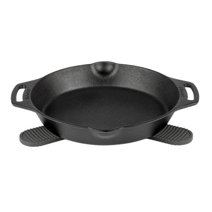 Cast iron skillet resting on a pair of black silicone trivets with textured grips, designed for safe handling of hot cookware in kitchen, camping, and cookware collections.