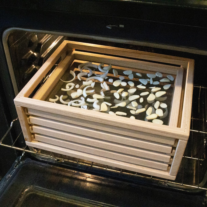 Handcrafted solid oak food drying rack with fiberglass screens filled with sliced onions and garlic, placed in an oven for food preservation, USA made, featured in Kitchen & Food and Drying collections.
