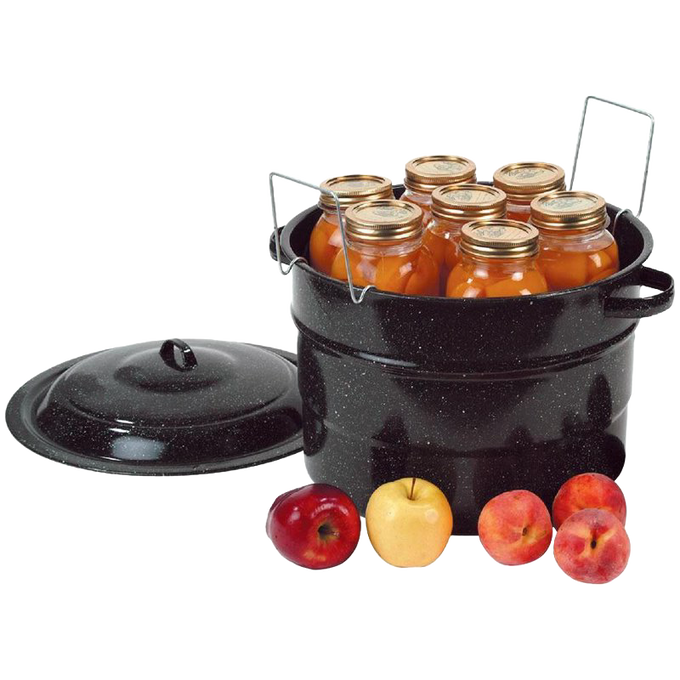 Black speckled enamelware canner filled with sealed glass jars of preserved fruit, with a matching lid set aside and fresh apples and peaches nearby, ideal for food preservation and canning.